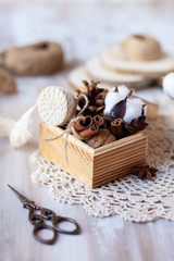 Family time to wrap christmas presents! Ideas for hand made gifts decor in rustic style, natural ingredients, cozy mood. Wooden background, scissors, lace, cones, cinnamon and cotton. Zero waste 