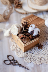 Family time to wrap christmas presents! Ideas for hand made gifts decor in rustic style, natural ingredients, cozy mood. Wooden background, scissors, lace, cones, cinnamon and cotton. Zero waste 