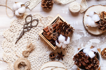 Time to wrap christmas presents! Ideas for hand made gifts decor rustic style, natural ingredients, cozy mood. Wooden background, scissors, rope, lace, cones, cinnamon and cotton. Flat lay top view