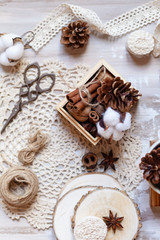 Time to wrap christmas presents! Ideas for hand made gifts decor rustic style, natural ingredients, cozy mood. Wooden background, scissors, rope, lace, cones, cinnamon and cotton. Flat lay top view