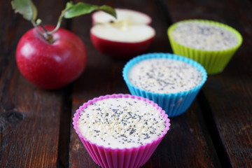 Dessert of caramel and apples in colored molds on a dark wooden table