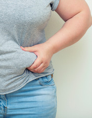 Obesity. Obese Woman Holding His Belly Fat With Both Hands Giving An Expression Of Shock.