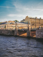 Obraz premium View of the embankment in the sunset rays in the evening in summer in St. Petersburg, in the foreground the boat sails along the river
