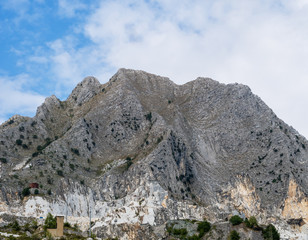 Mountain peak in the Apuan Alps, Italy, showing marble quarries at base.