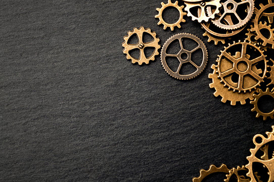 Steampunk accessories and old technology conceptual idea with border made of a group brass cog wheels on dark texture background with copy space © Victor Moussa