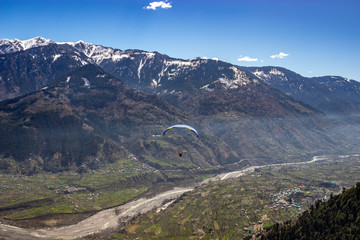 Paragliding in snow cap mountains of himalayas