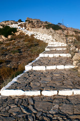 Fototapeta na wymiar Greece, a path leading to a monastery on the island of Sikinos. The path is steep and winding and reflects achievement, hard work and a clear goal.