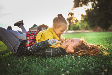 Hipster Mom and Toddler child on grass, top view