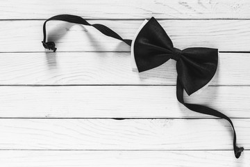 black bow tie on white wooden background