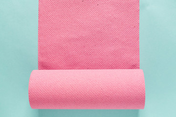 pink paper towels isolated on blue paper background. flat lay