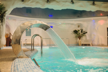 Fototapeta na wymiar the interior of the aquazone in a spa salon, swimming pools and a water fall