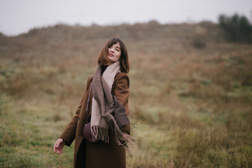 Woman in brown stylish cashmere coat posing on autumn background. - obrazy, fototapety, plakaty