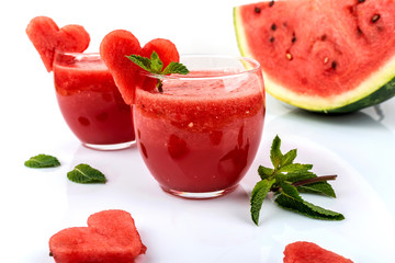 Watermelon smoothie fresh juice with mint and pieces in the shape of hearts on a white background. Summer healthy drinks.