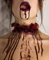tasty blood flows from the open mouth with tongue and neck with red roses. halloween concept,...