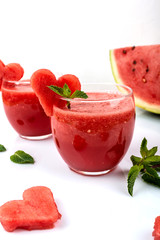 Watermelon smoothie fresh juice with mint and pieces in the shape of hearts on a white background. Summer healthy drinks. Close-up.