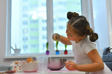 Little girl preparing cookies in kitchen at home. Cooking homemade food.Cooking is fun .Ingredients for baking Easter cake