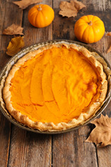 traditional pumpkin pie on wood background