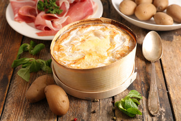 baked mont d'or, french dish, with ham and potatoes