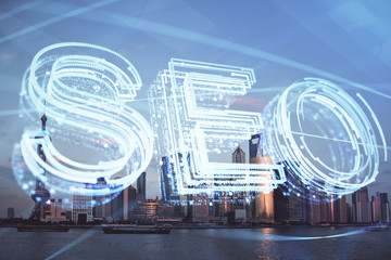 SEO hologram on city view with skyscrapers background double exposure. Search optimization concept.