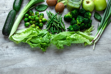 Fresh green food on a light table. Avocados cucumbers cabbage apples beans kiwi onions broccoli. The concept of healthy food, detox vegetarianism. Copy space flat lay.