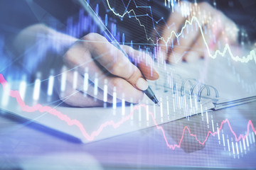 Forex graph on hand taking notes background. Concept of research. Multi exposure