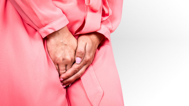 Gynecologic problems, urinary incontinence, female health. Woman holds hands between her legs