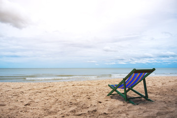 A single beach chair by the sea with blue sky background