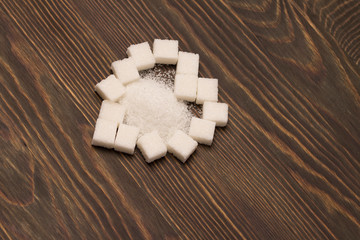 White heart shaped sugar on a dark wood background 