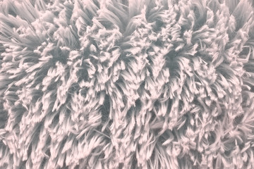 Pink sheepskin rug background. Fabric made of faux fur with long nap used for clothing and furniture and bedspreads. Detail of soft hairy skin material. Abstract Pink wool , fabric background.