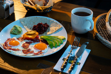 Fried egg with bacon served on wooden table and coffee and bread