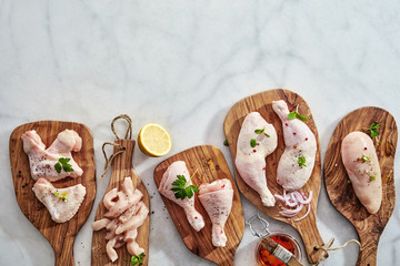 Bottom border on marble with raw chicken portions - obrazy, fototapety, plakaty