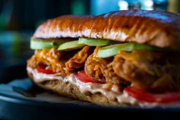 Chicken sandwich with tomato and sauce. Closeup shot 