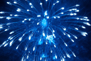 Blue firework in the night sky. Blue background