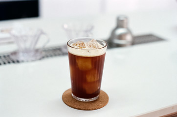 ice americano on white table in coffee shop background.