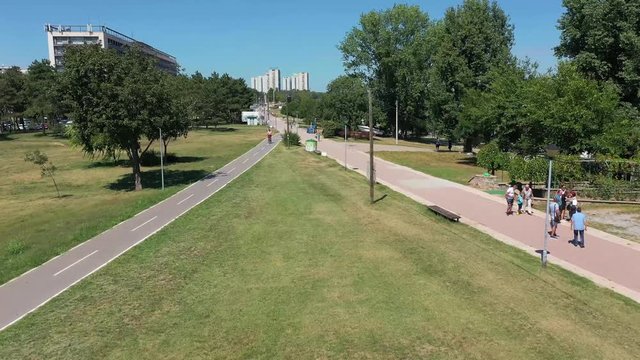 Take off through-the-trees drone shot of Usce park near Hotel Yugoslavia in Belgrade, Serbia