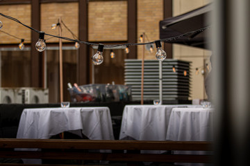 Bottles of beer in a plastic box on a summer evening. With lights. Round tables infort.