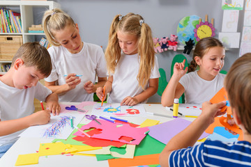 Fototapeta premium Mother with children. Creative arts and crafts project at school or at home.