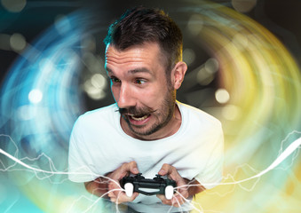 Enthusiastic gamer. Joyful young man holding a video game controller being full of emotions...