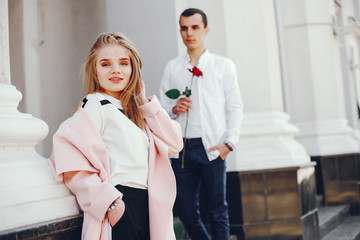 Fototapeta premium beautiful and stylish blonde along with her handsome guy standing near building in the summer city