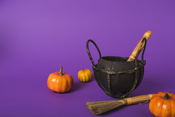 Pumpkins and brooms near cauldron