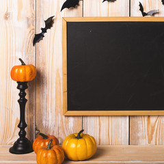 Fake pumpkins near chalkboard and bats