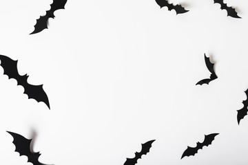 Paper bats hanging on white wall