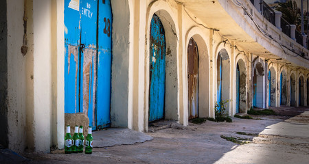 Grüne Bierflaschen vor blauen Garagentoren