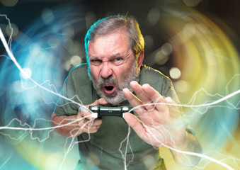 Breathtaking new life. Senior man holding a video game controller isolated on colorful background....
