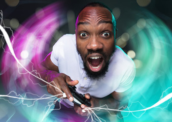 Passioned for winning. Young man holding a video game controller isolated on colorful background....