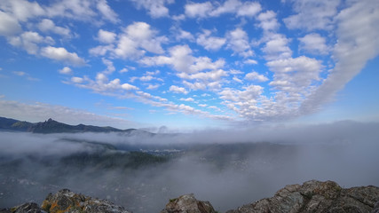 View from the mountain. Rocks in the background. Fog. Clouds in blur. Peak of the mountain,  home.
