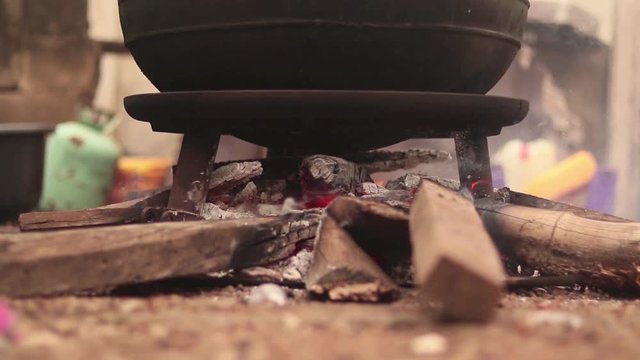 Smoldering wood underneath pot in traditional African village. Filmed in the city Ibidan, in Oyo, Nigeria.