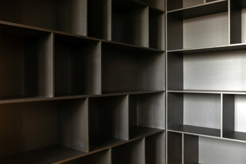 Variously shaped empty shelves of wooden cabinet ready for content in corner