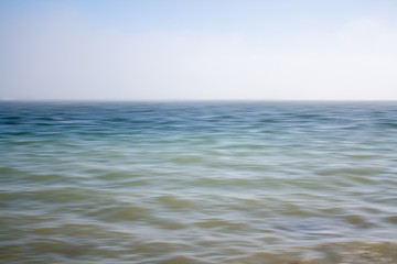 An abstract seascape with blurred panning motion with mussel rafts at the back
