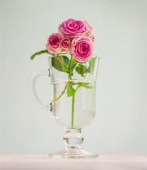 Romantic background: a branch of roses in a glass. A festive concept for Valentine's Day, wedding, birthday, a significant date.
